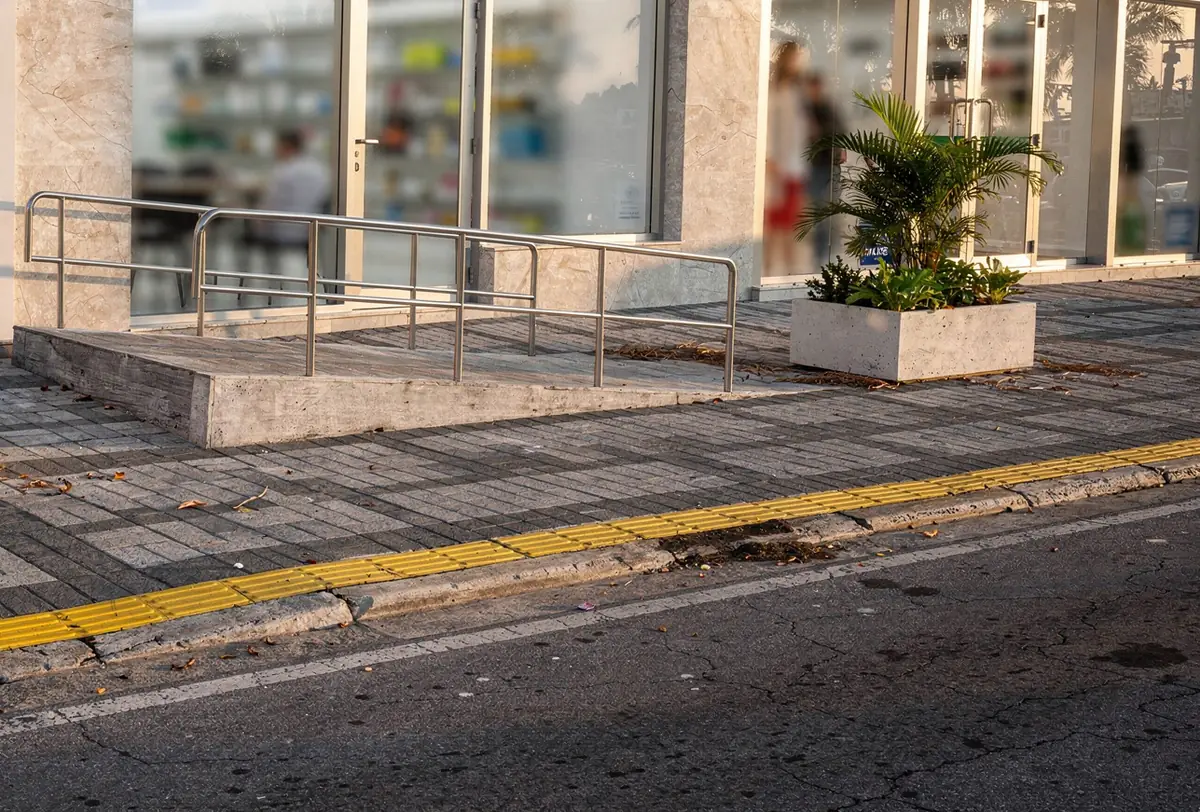 Calçada de comércio em paver com rampa e piso tátil